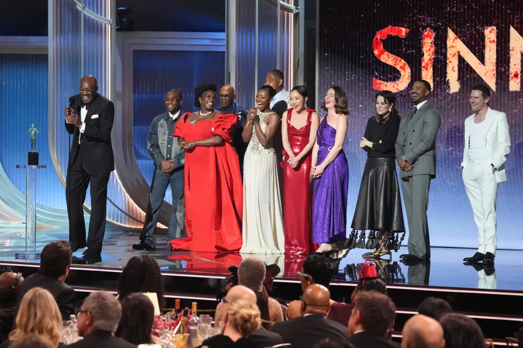 Delroy Lindo, Miles Canton, Wunmi Mosaku, Omar Benson Miller, Jayme Lawson, Li Jun Li, Lola Kirke, Francine Maisler, Michael B. Jordan, and Jack O'Connell accepting an award on stage.