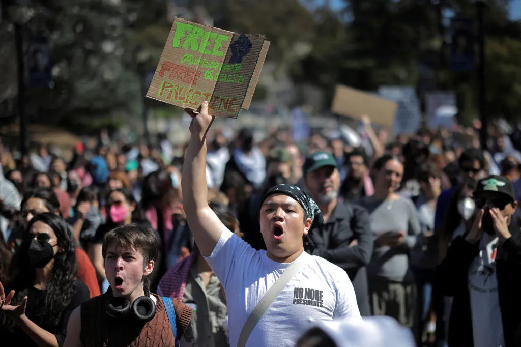 A protestor holds a sign reading 