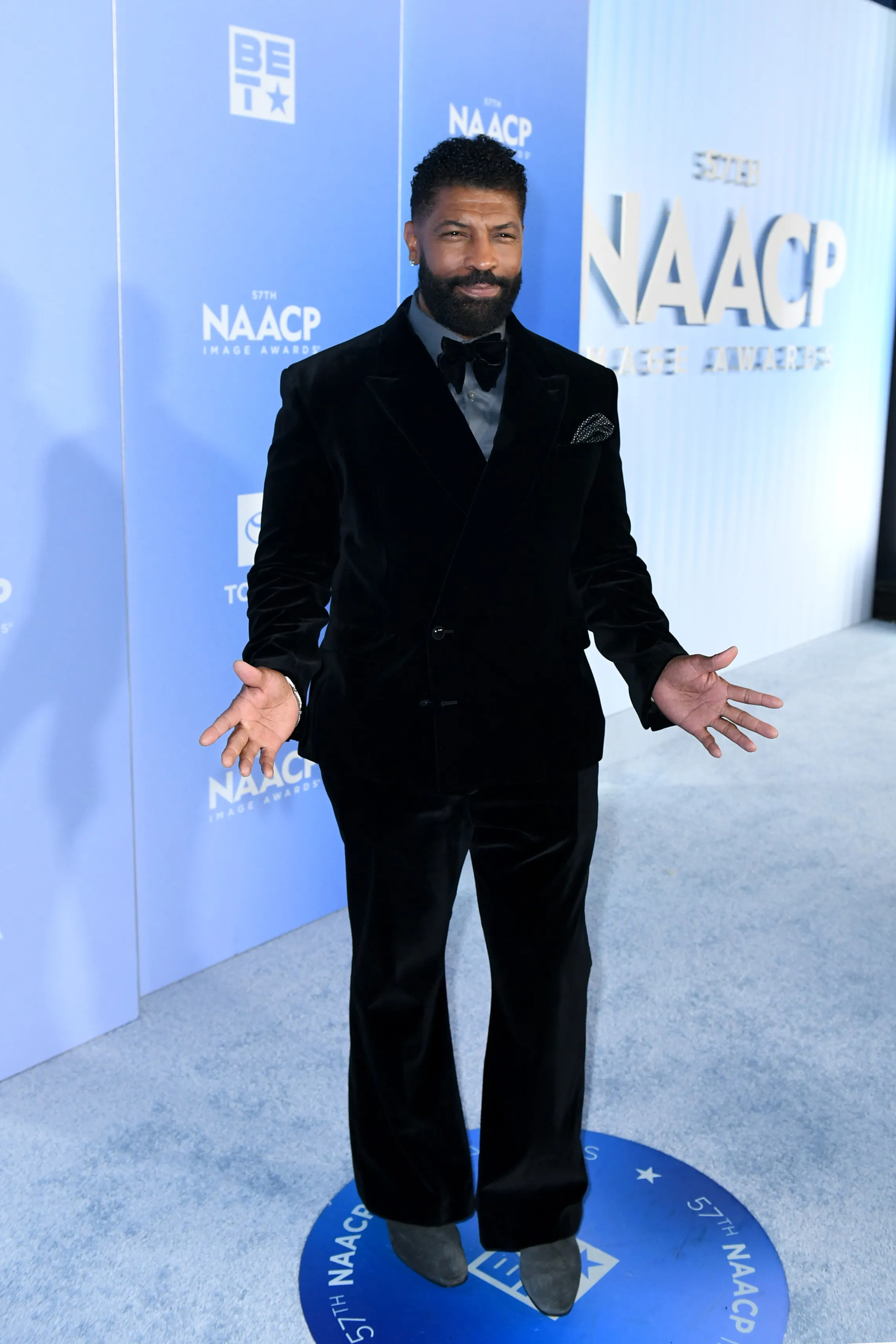 Deon Cole posing on the red carpet at the 57th NAACP Image Awards.