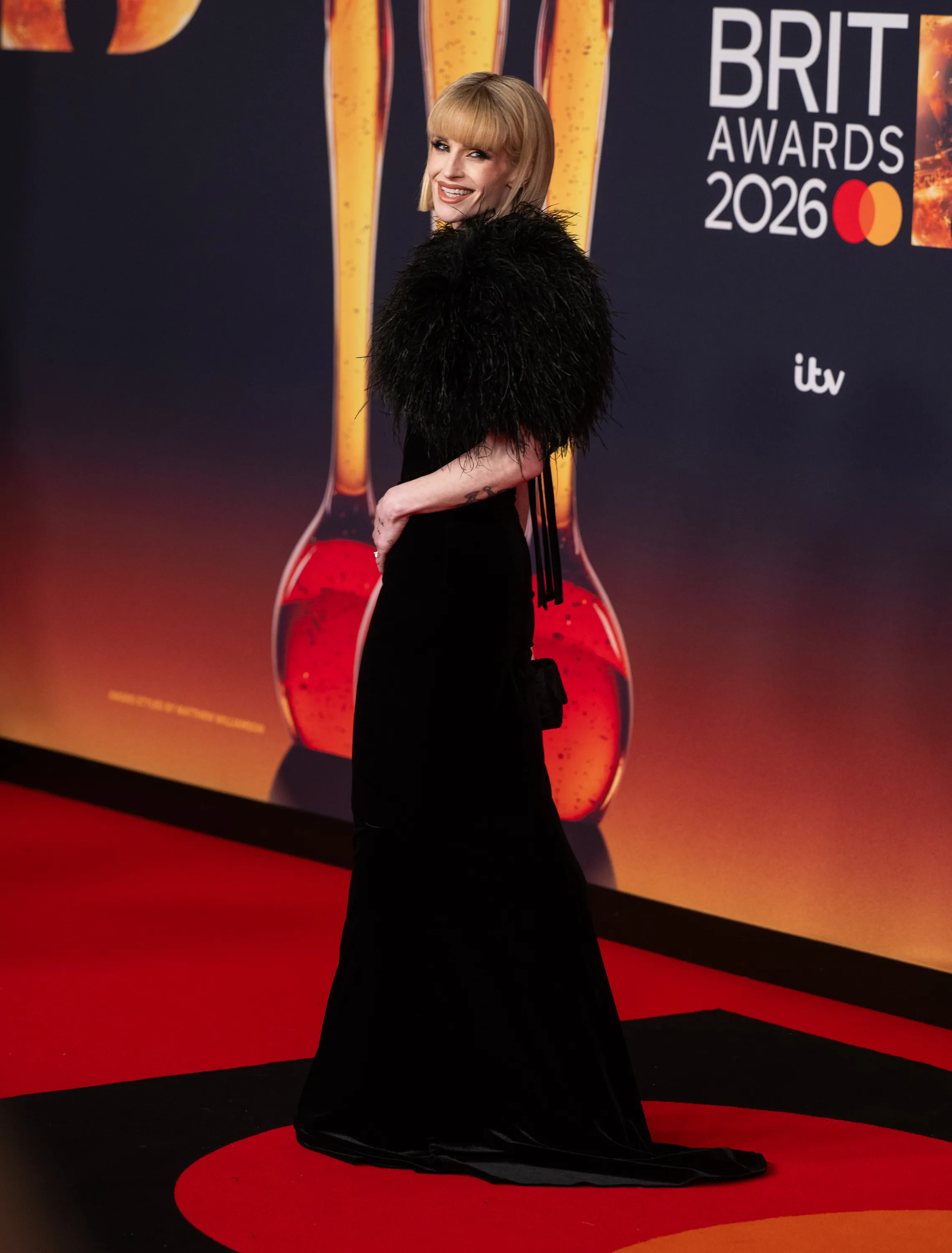 Kelly Osbourne in a black feathered and velvet gown at the Brit Awards 2026.