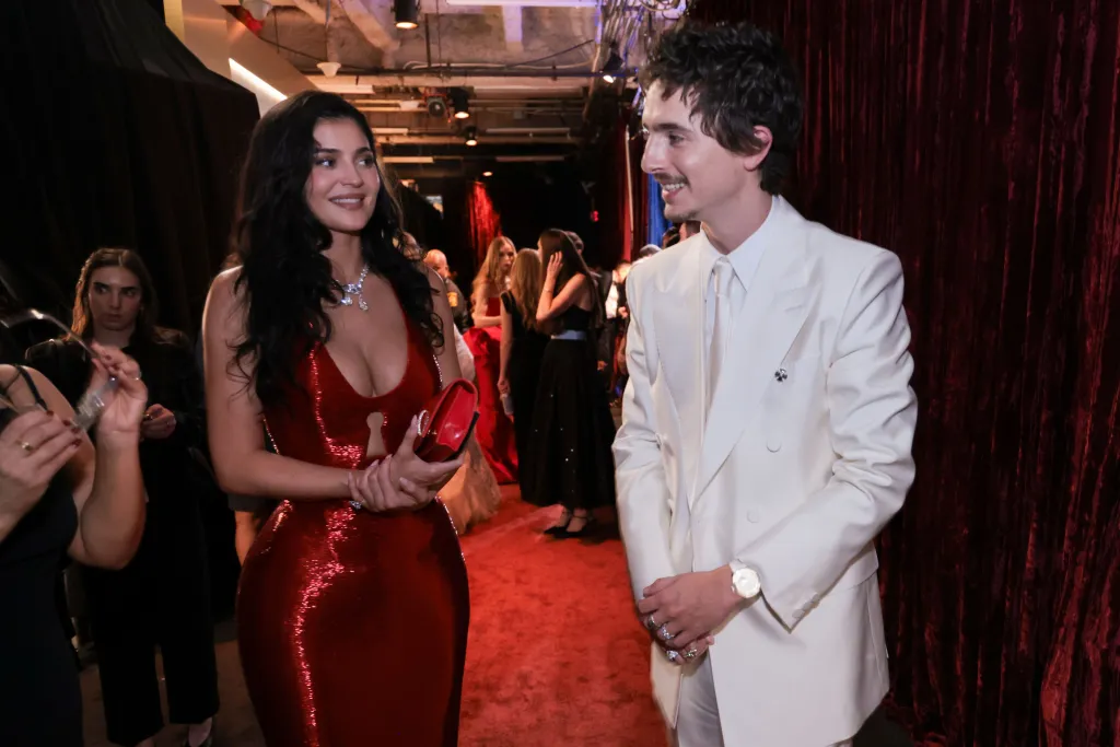 Kylie Jenner in a red dress with a keyhole neckline and Timothée Chalamet in a white suit at the 98th Annual Academy Awards.