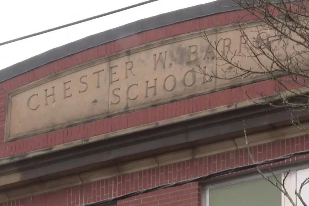 Chester W. Barrow School name carved into a stone banner on a brick building.