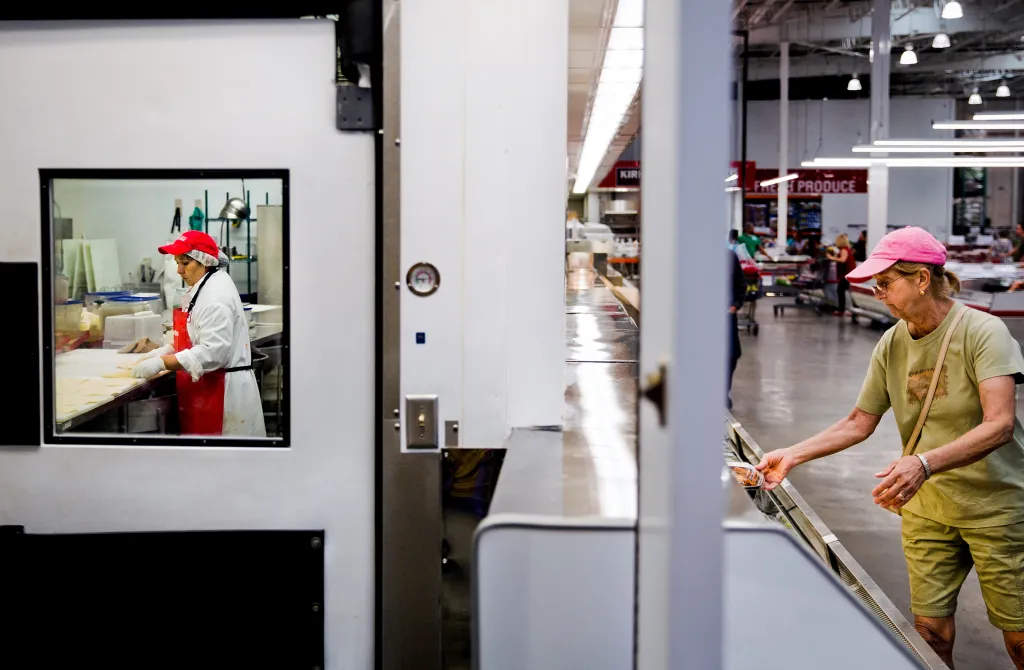 An employee works in the deli department at a Costco store.