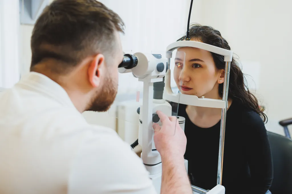 An ophthalmologist examining a woman's eye with modern ophthalmological equipment.