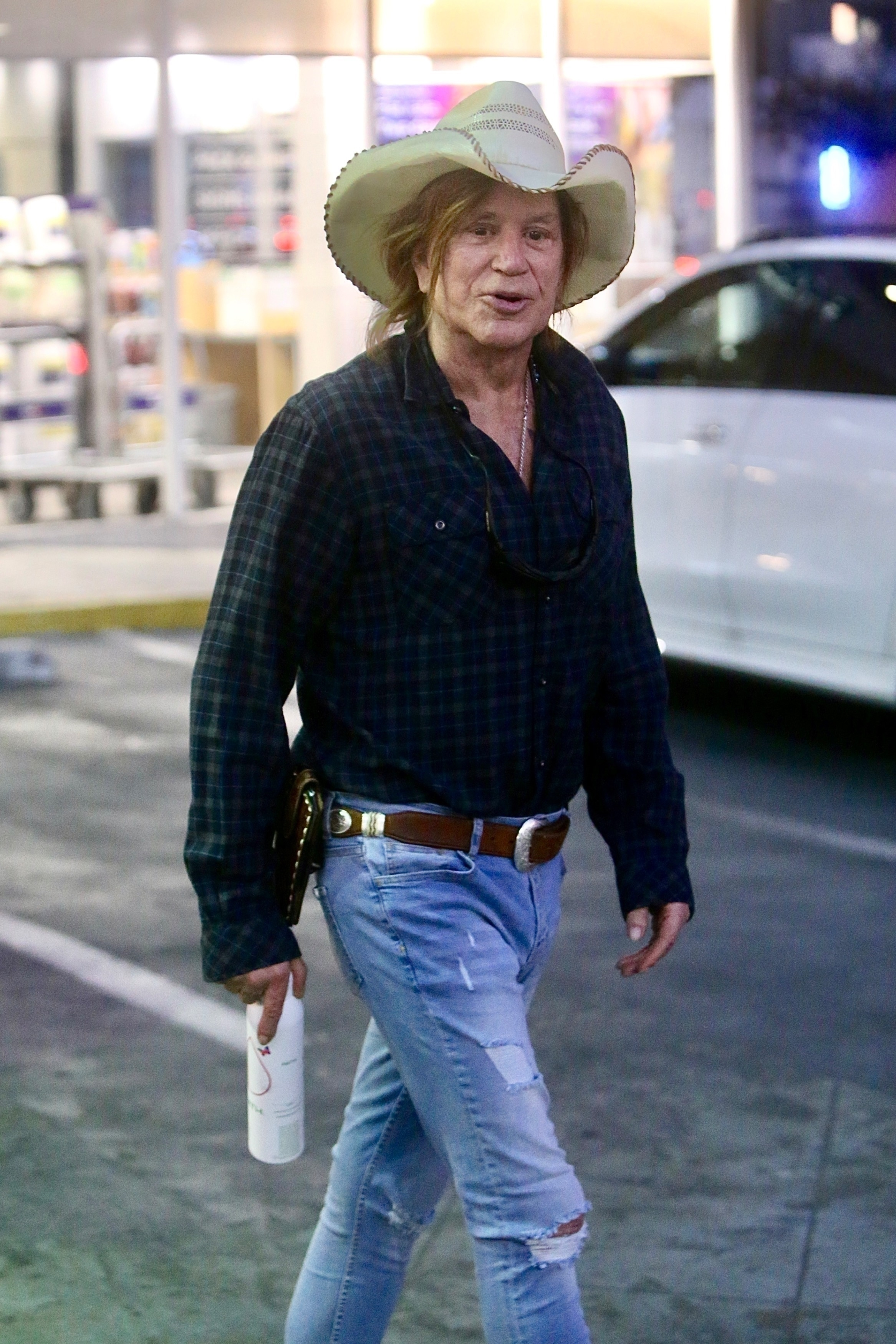 Actor Mickey Rourke in a cowboy hat and plaid shirt.