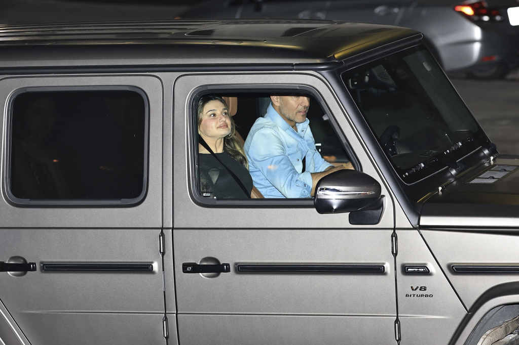 Mauricio Umansky and a woman in the passenger seat of a car at night.