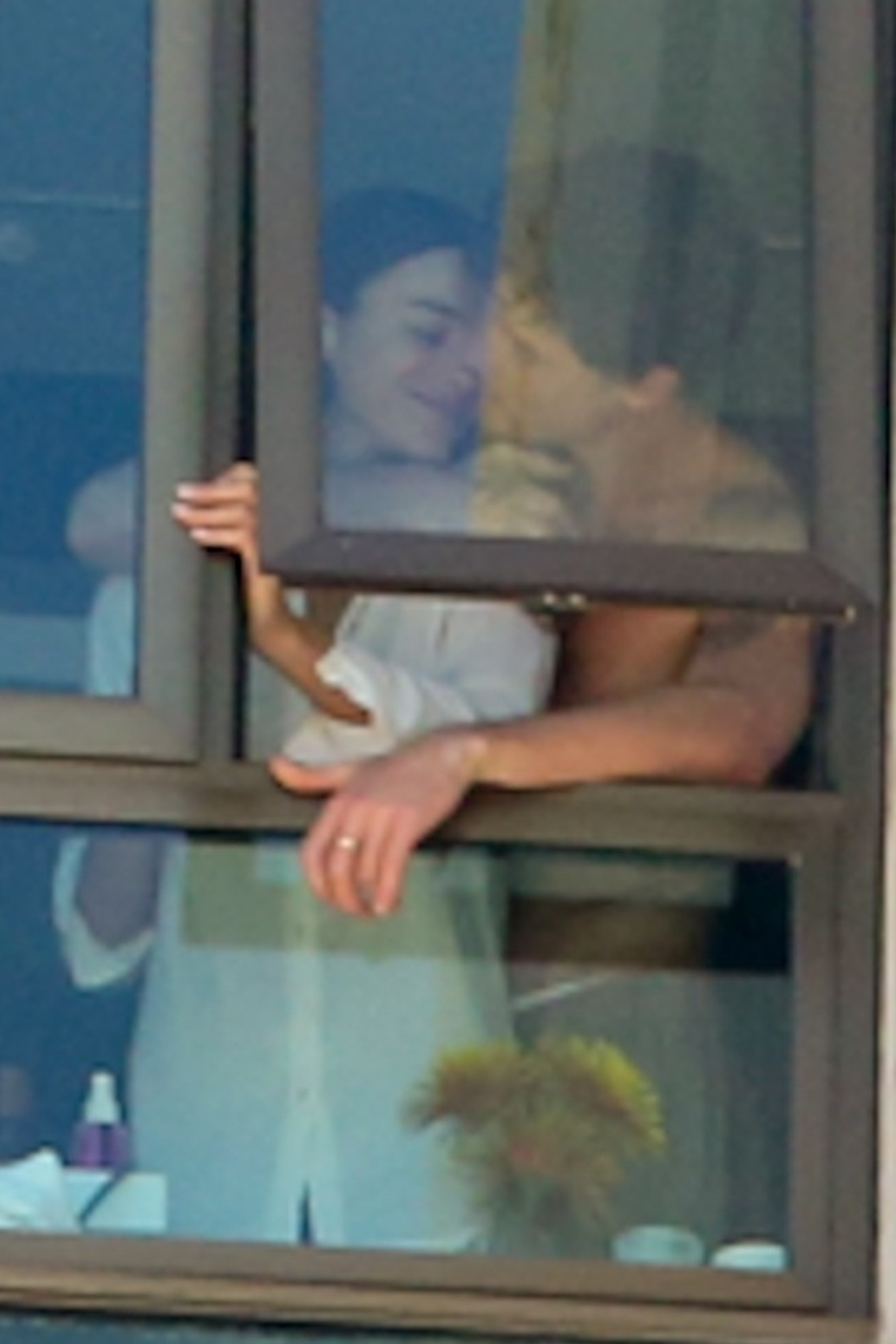 Mendes stood behind his girlfriend as she leaned in for a kiss.