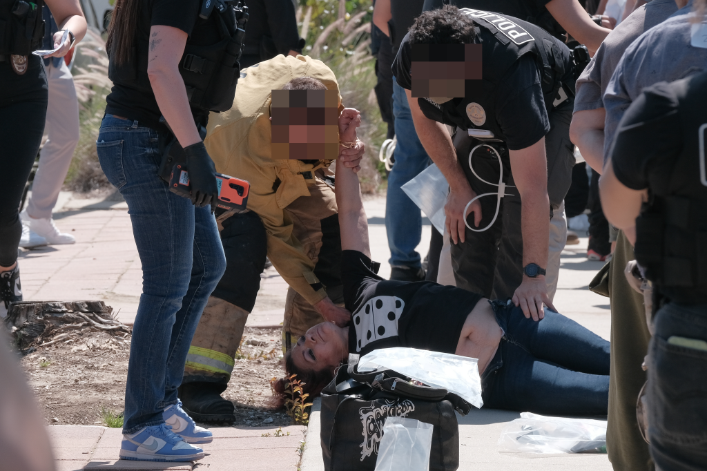 Police officers arresting a person on the ground during an illegal casino bust.