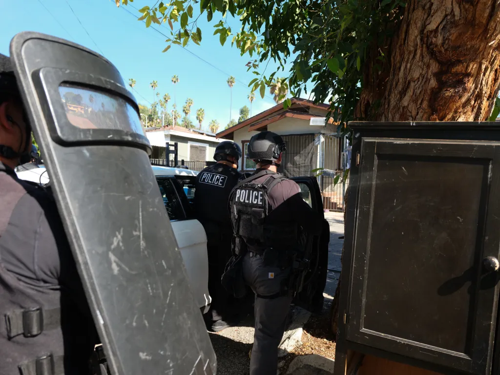 Police officers with protective gear during an arrest.