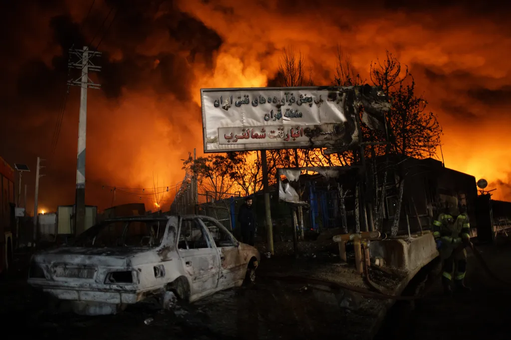 Destroyed vehicles and a burning oil depot in Tehran, Iran.