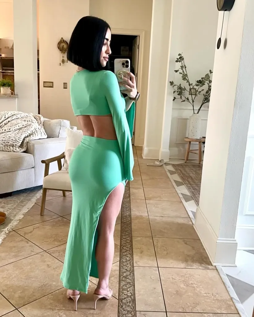 A woman taking a selfie in a green dress. 