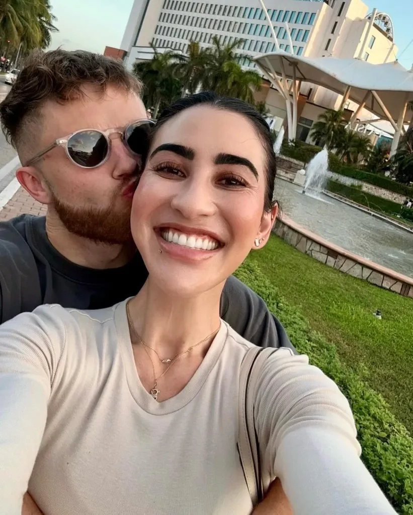 Stephanie Buttermore smiling while her partner, Jeff Nippard, kisses her cheek.