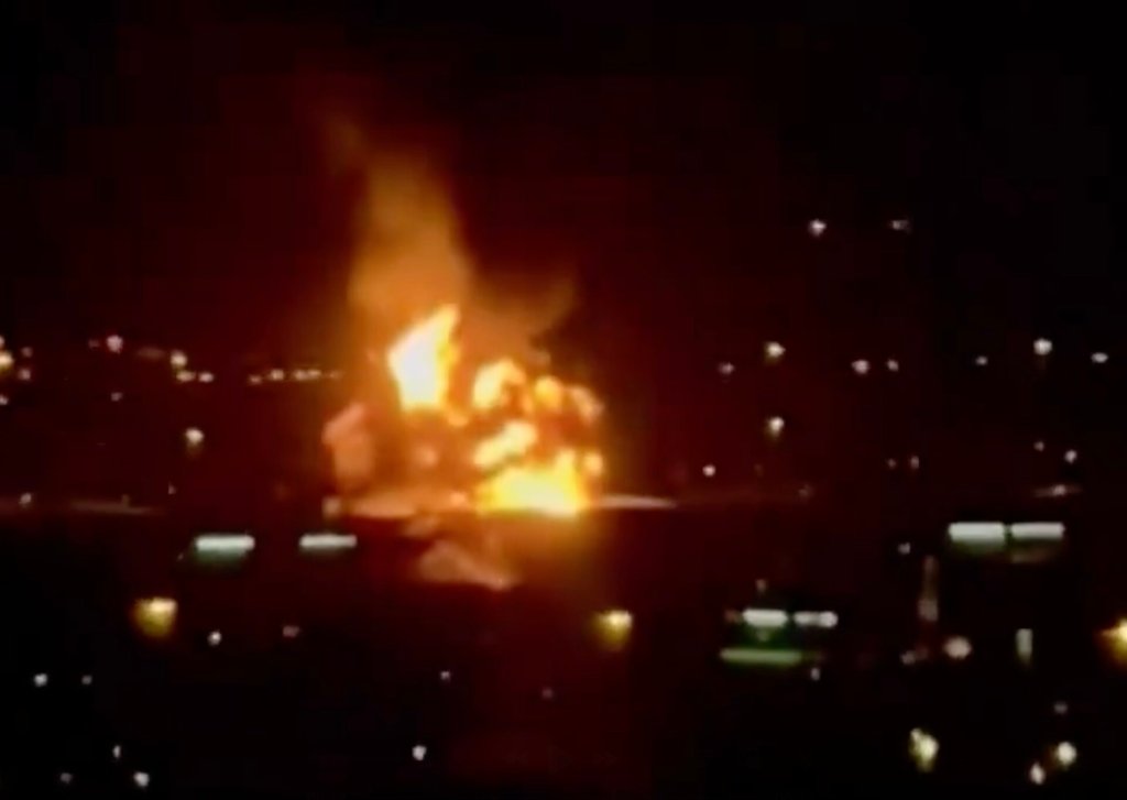 Nighttime video grab showing a massive explosion and fire from a drone strike on a fuel tank near Dubai Airport.