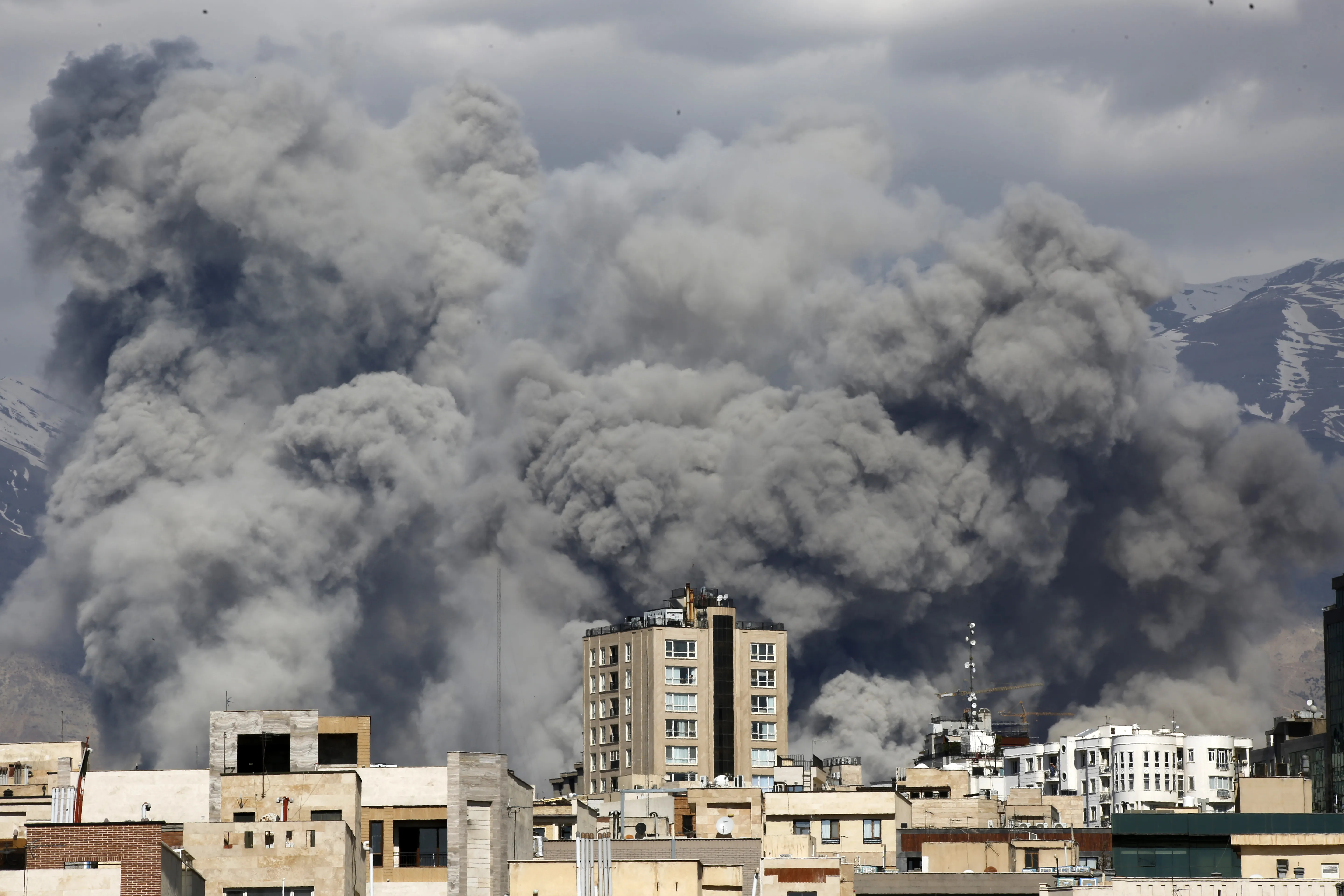 Smoke rising behind buildings in Tehran
