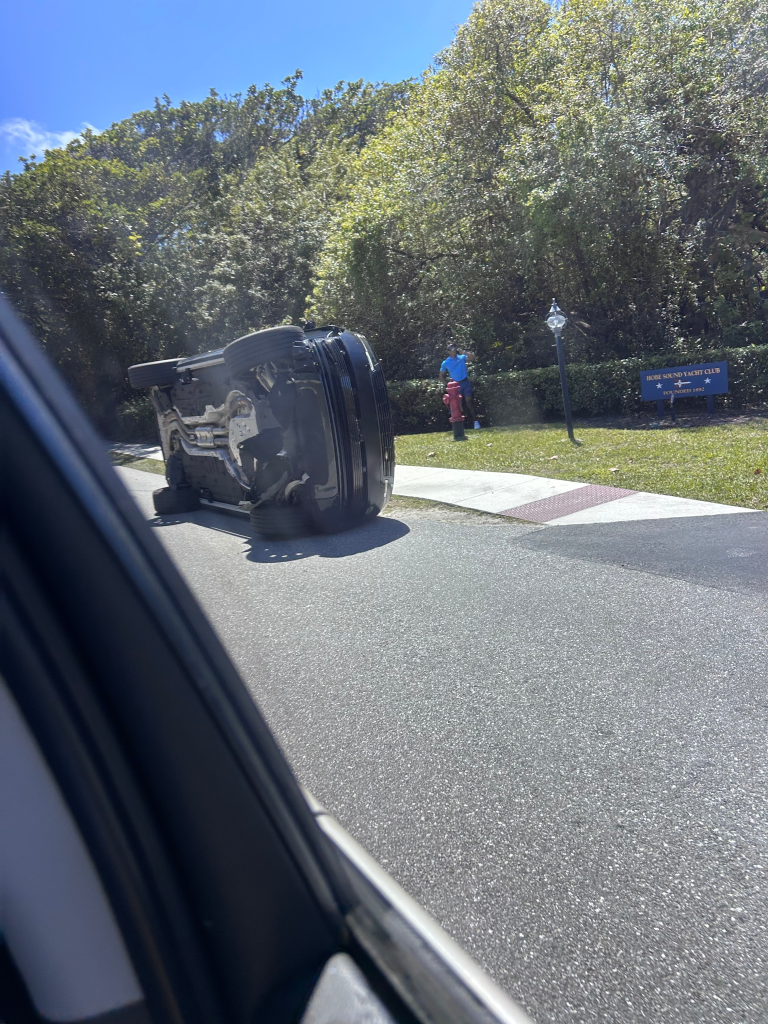 Tiger Woods stands by his overturned vehicle near the Hobe Sound Yacht Club.