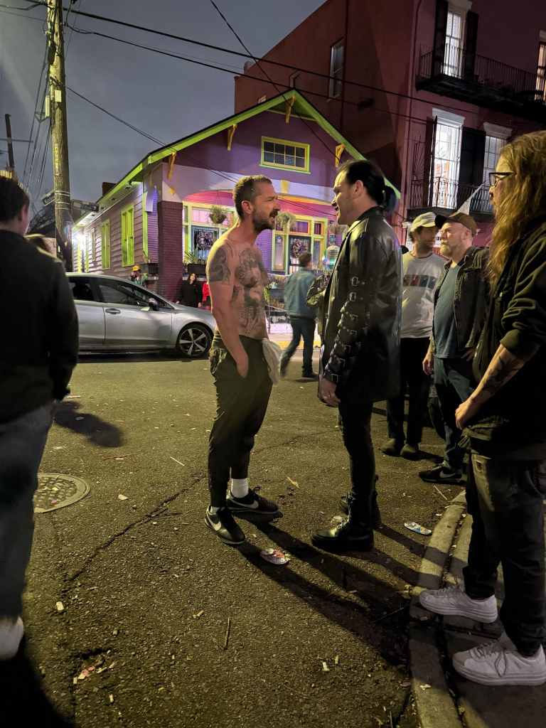 Shia LaBeouf, shirtless and covered in tattoos, headbutts a man on the street.