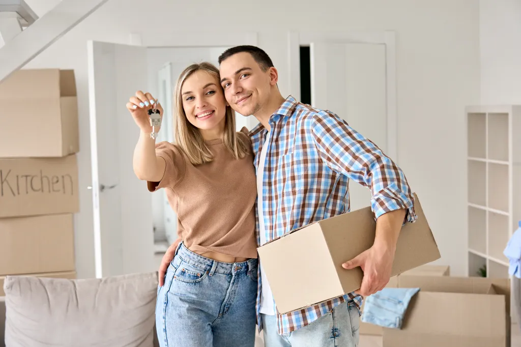 Happy young couple holding keys in their new home.