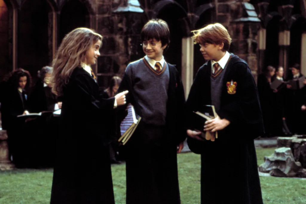 Emma Watson, Daniel Radcliffe, and Rupert Grint in robes and school uniforms for