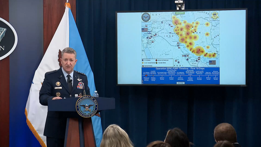 Military briefing on Iran with a general speaking and a map of the region showing various bases and strikes.