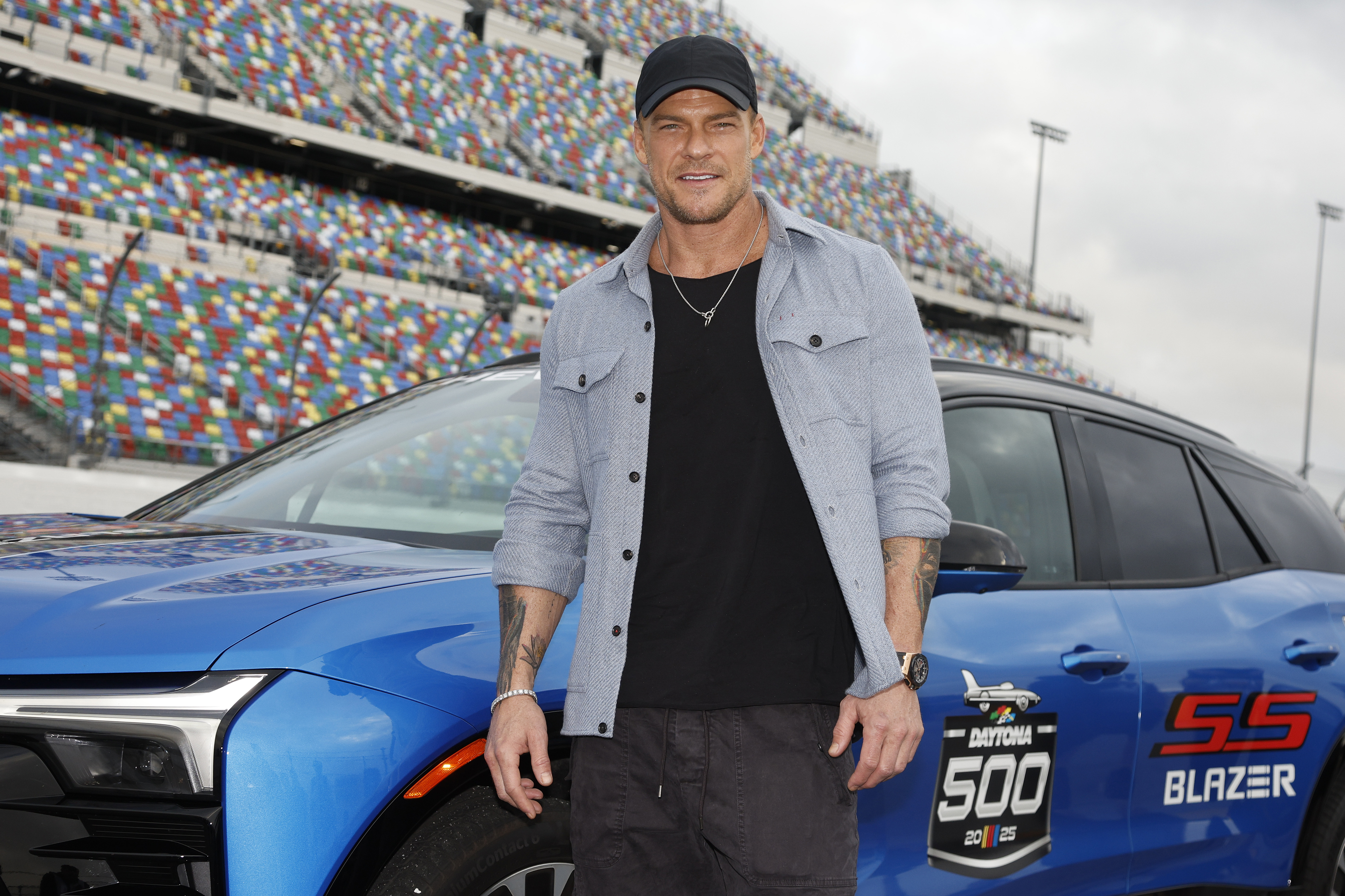 Honorary pace car driver Alan Ritchson poses with the Daytona 500 pace car.