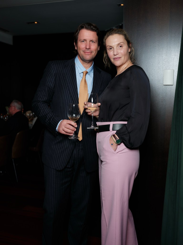Salvatore Ferragamo and a woman posing with wine glasses at a wine presentation event.