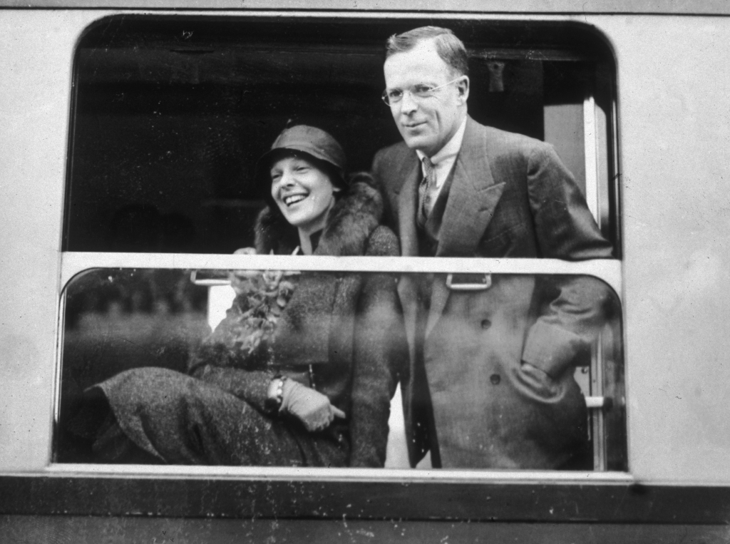 Amelia Earhart and George Palmer Putnam looking out of a train window.