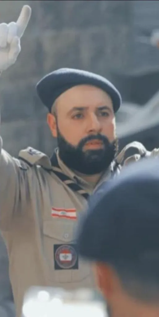Ibrahim Muhammad Ghazali in uniform raising his hand.