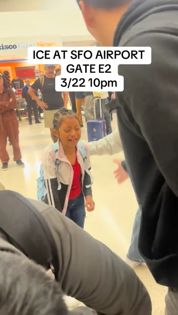 A crying child stands in an airport terminal, as text overlay reads, 