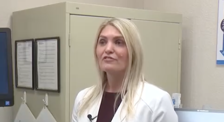 Woman with long blonde hair wearing a white lab coat.