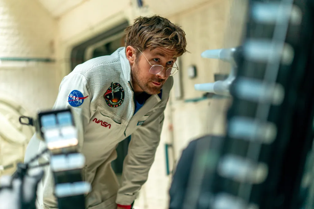 Ryan Gosling as an astronaut in a white NASA jumpsuit.