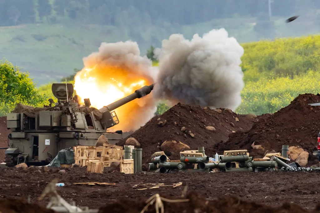 A tank firing with a large explosion of fire and smoke from its barrel.