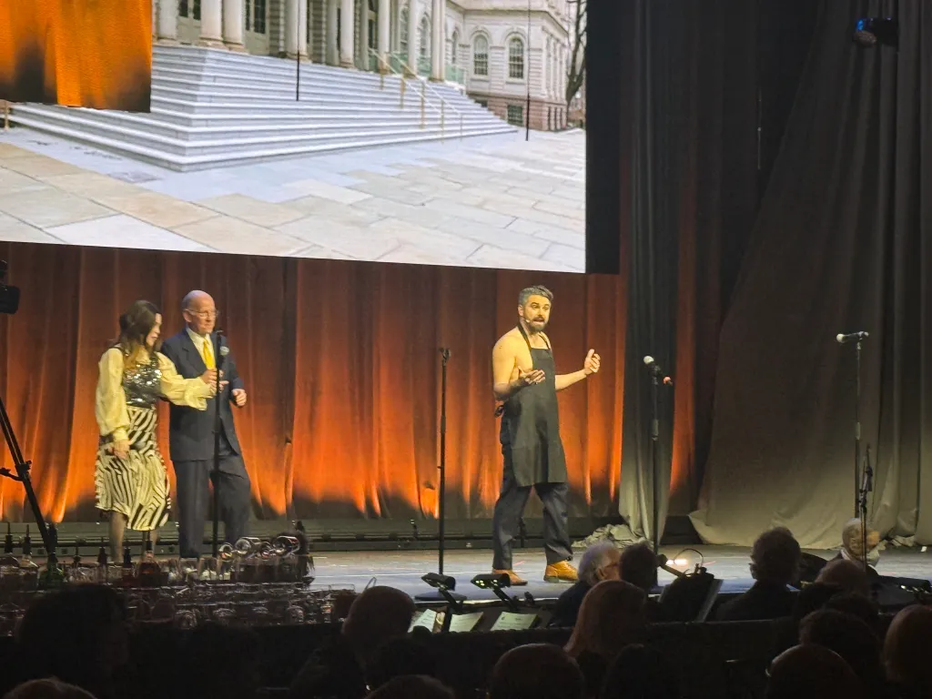 Jeff Coltin appears onstage as Mayor Zohran Mamdani, donning an apron during the Inner Circle’s 2026 dinner at the Ziegfeld.