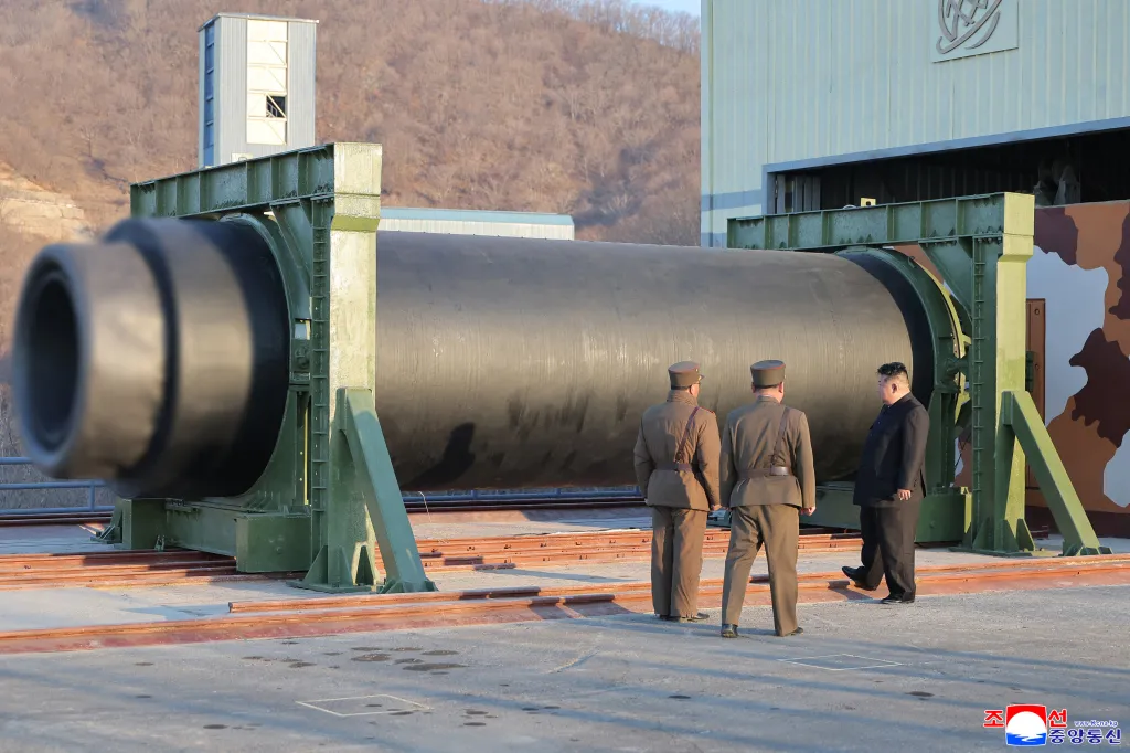 North Korean leader Kim Jong Un and military officials inspect the solid-fuel rocket engine.
