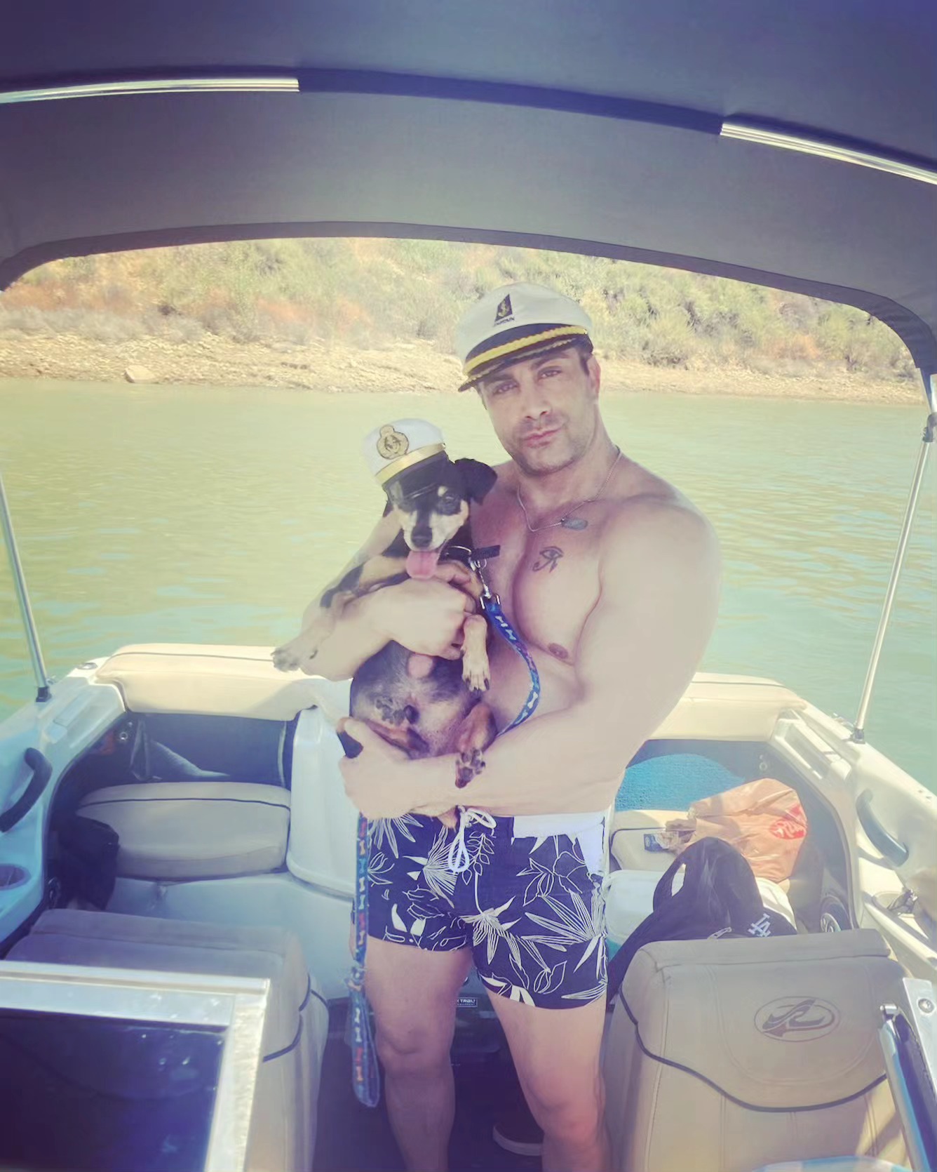 York shirtless on a boat while holding a dog in an undated photo post to Instagram.