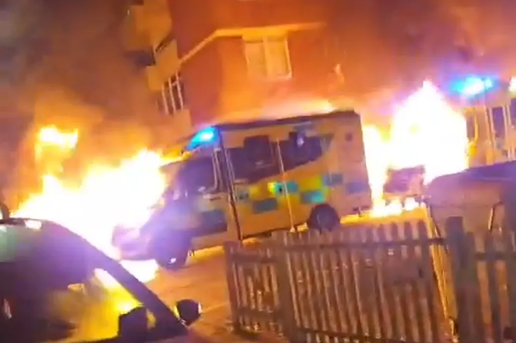Ambulances engulfed in flames with bright orange and yellow fire.