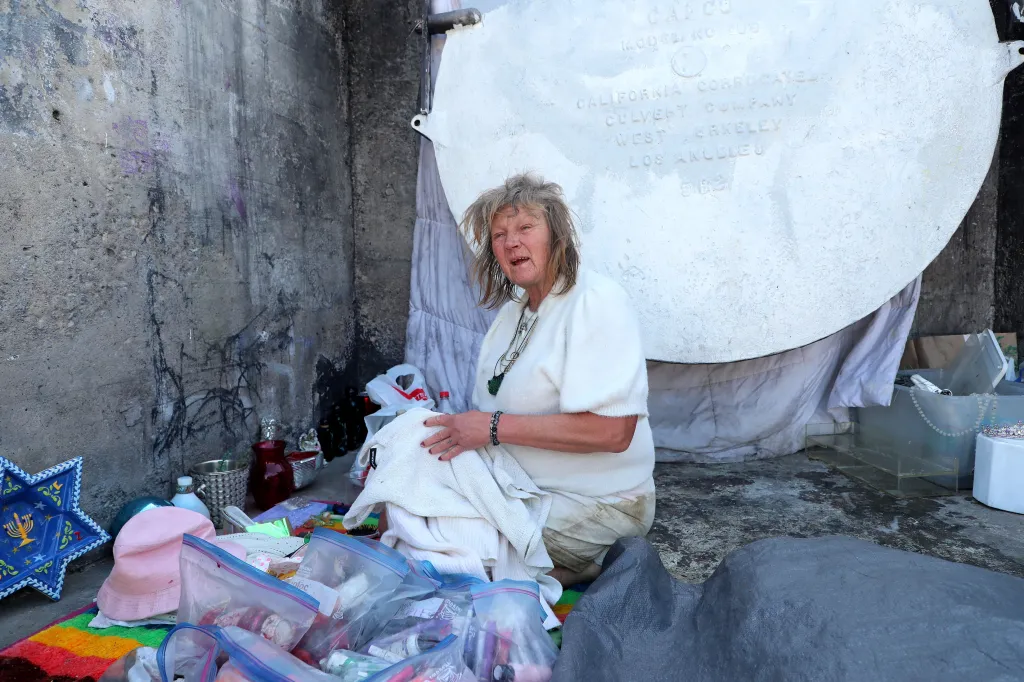 Ises, who is homeless, washes her clothes in the LA River.