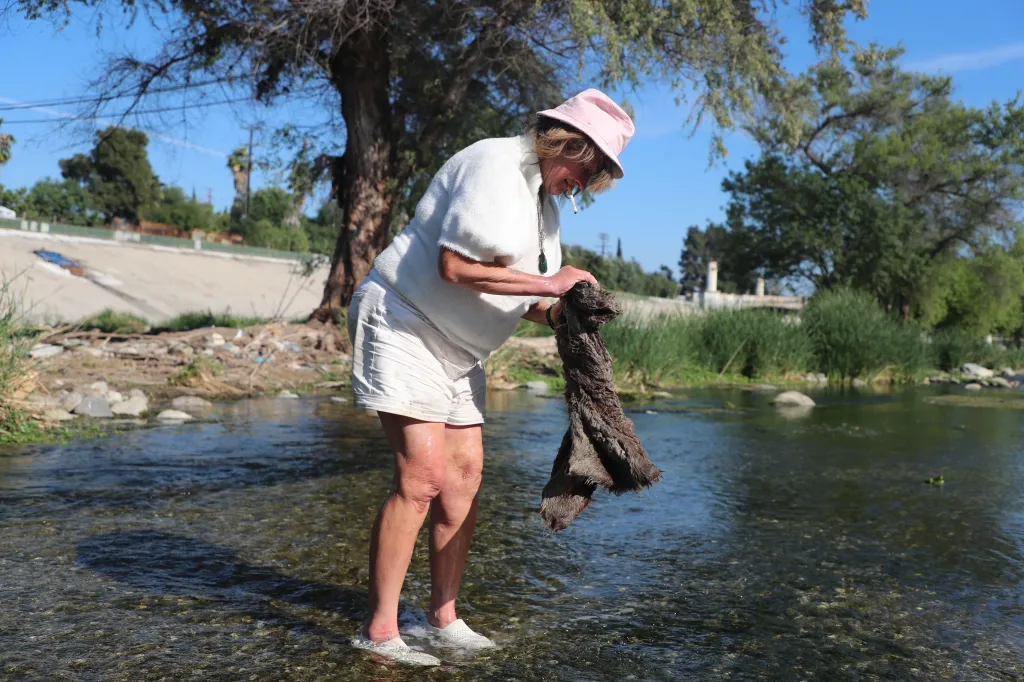 Homeless woman Ises washes her clothes in the Los Angeles River.