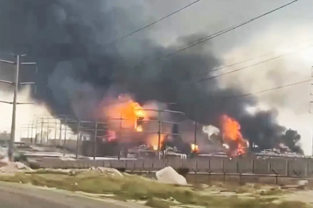 Large fire and thick black smoke rising from an industrial facility.