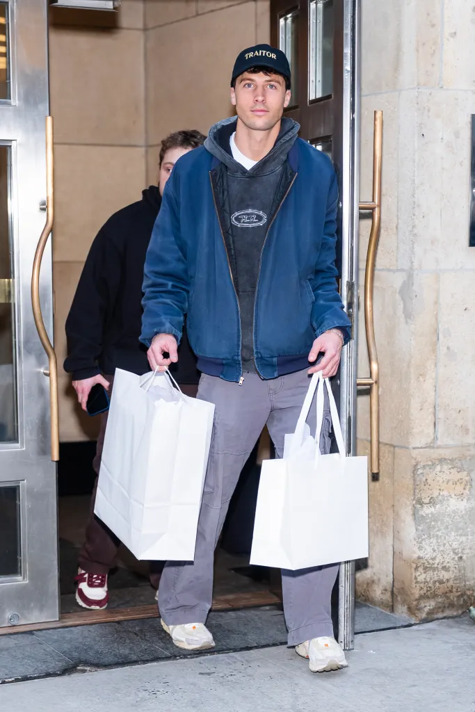 Jake Shane and Rob Rausch leaving a building with shopping bags.