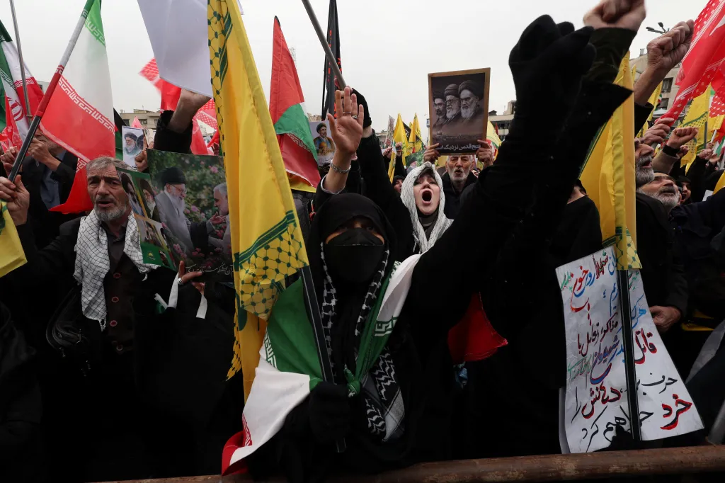 Protestors at the annual Al-Quds Day demonstration in Tehran, with flags and posters of leaders.