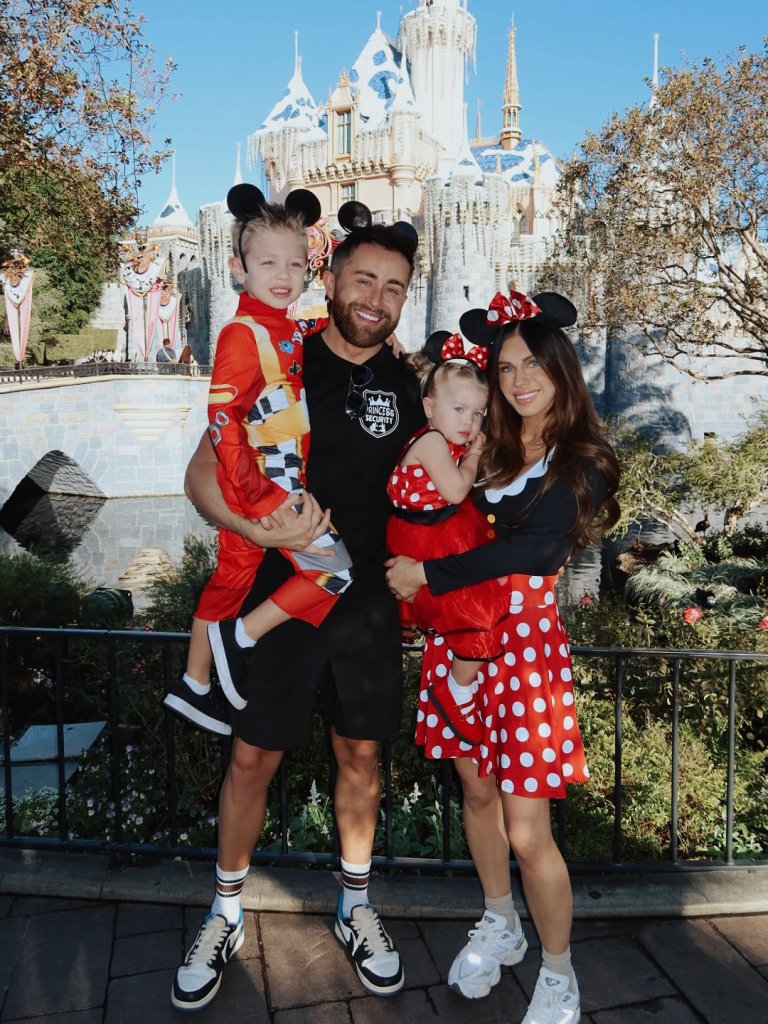 Jessi Draper and Jordan Ngatikaura with their children, dressed in Disney-themed costumes, in front of Cinderella's Castle.