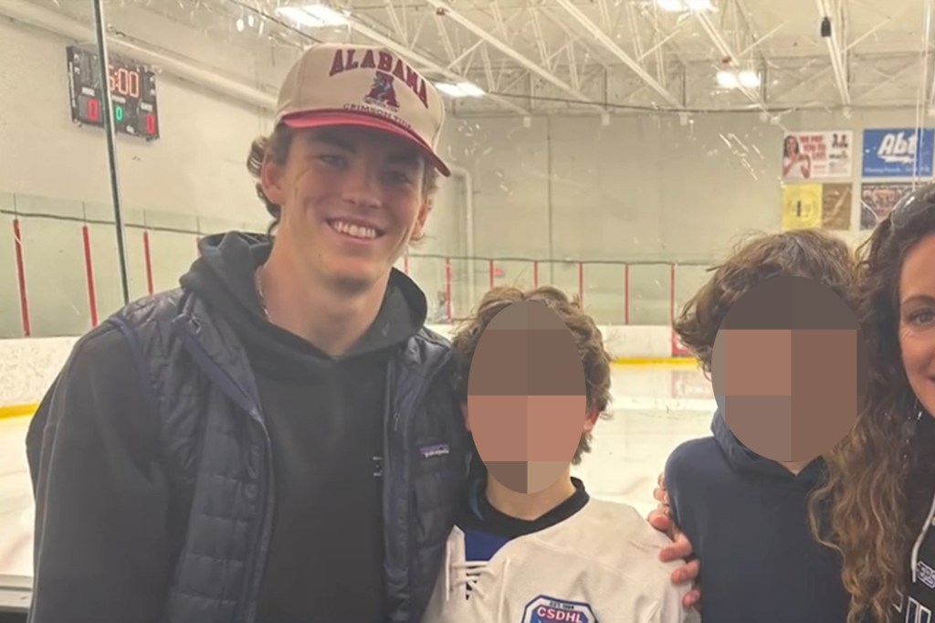 University of Alabama student Jimmy Gracey in a cap, smiling with children and a woman in an ice rink.