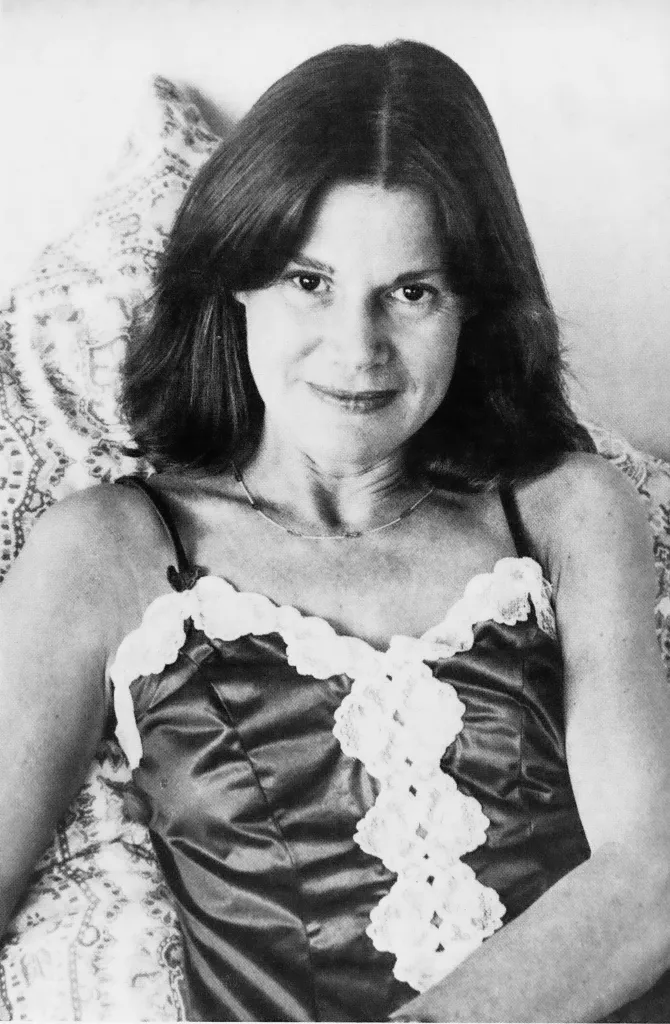 Black and white photo of Joan Neary smiling in a silky top with white lace.