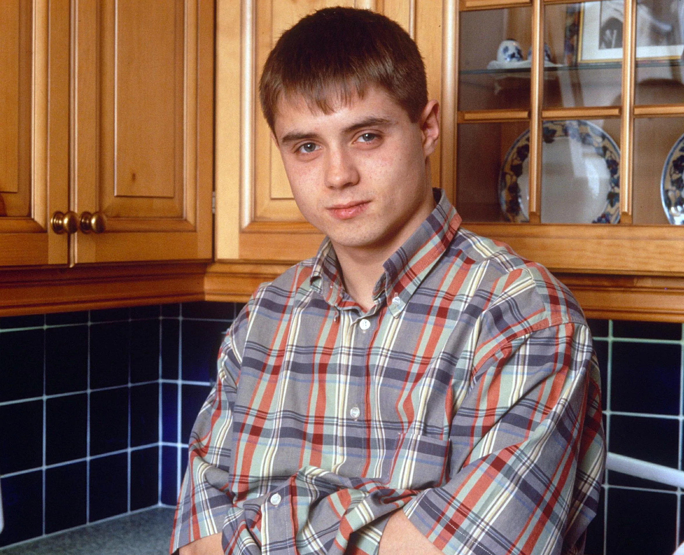 Headshot of actor John Alford in a kitchen.