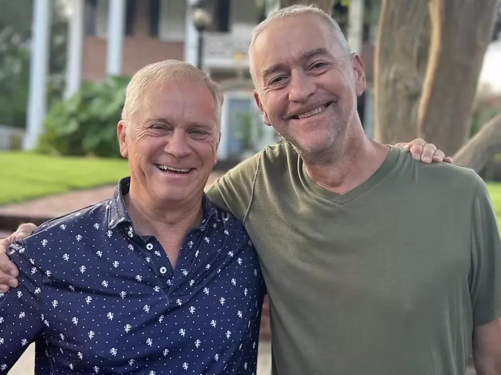John Logan and David Logan smiling with arms around each other.
