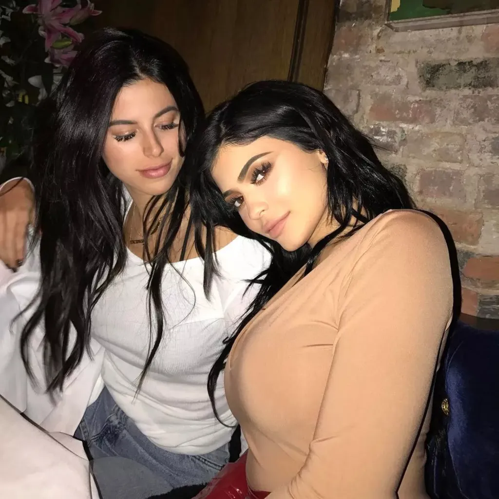 Kylie Jenner resting her head on Victoria Villarroel's shoulder.