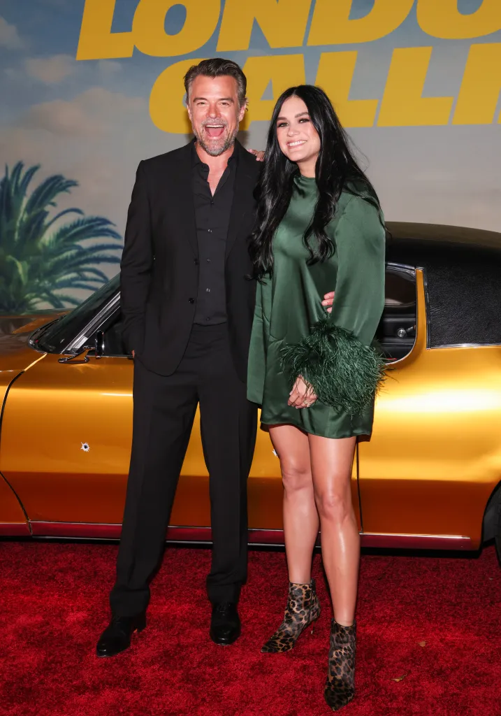 Josh Duhamel and Audra Mari pose on a red carpet at the Los Angeles premiere of