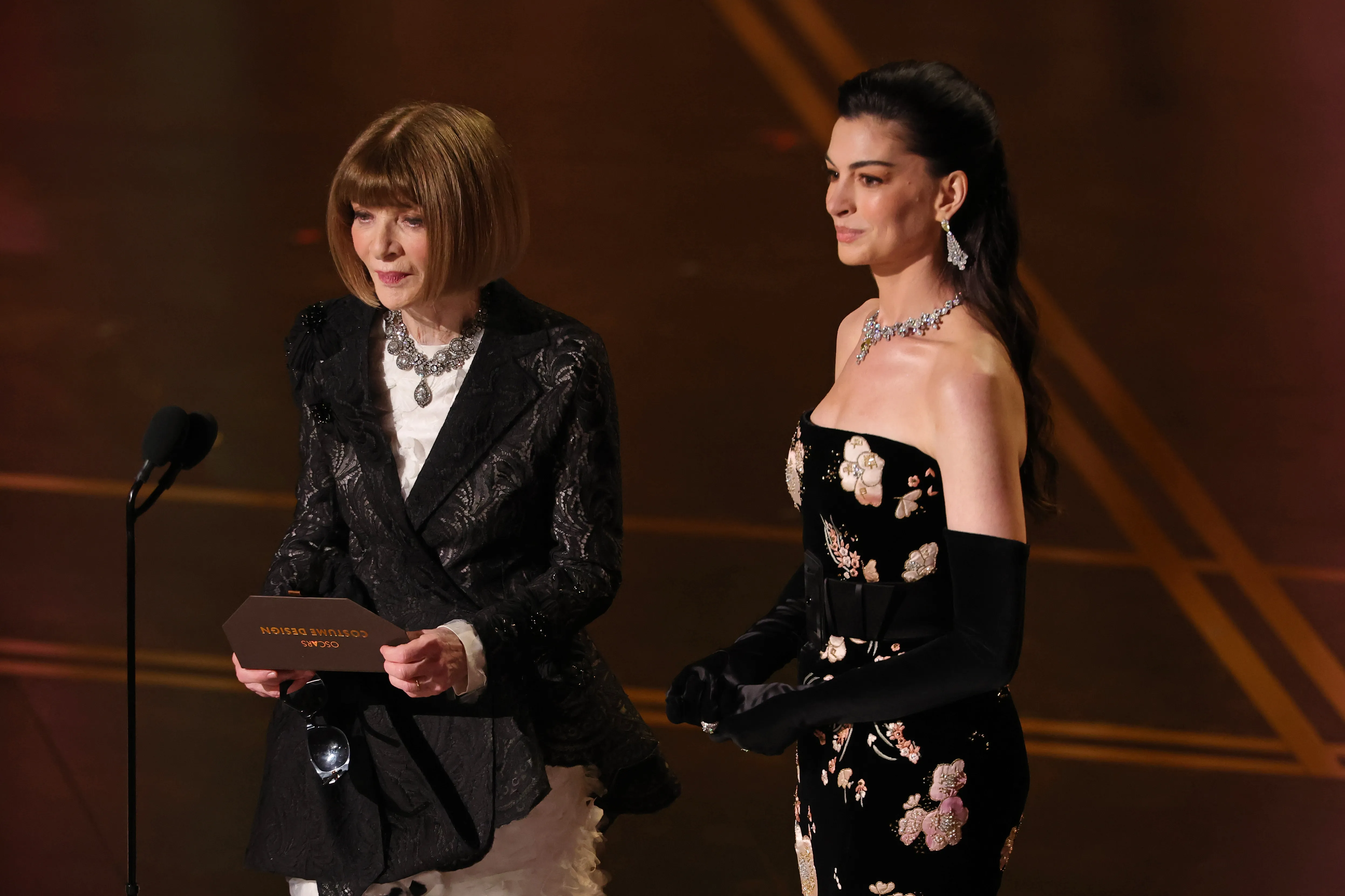 Anna Wintour and Anne Hathaway on stage presenting at the 98th Oscars.