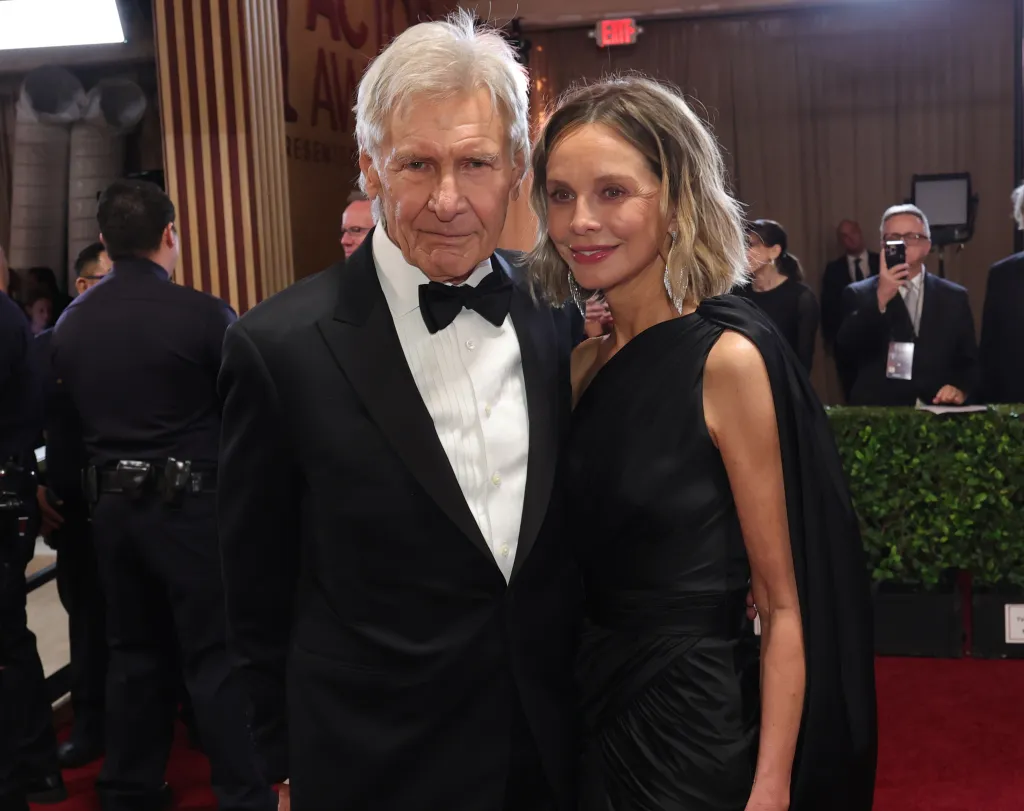 Harrison Ford and Calista Flockhart posing together on a red carpet.