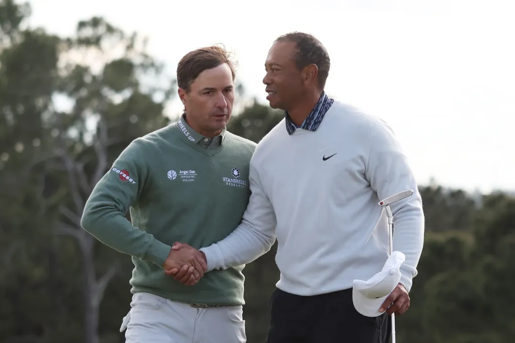 Kevin Kisner and Tiger Woods shake hands on the 18th green at the Masters.